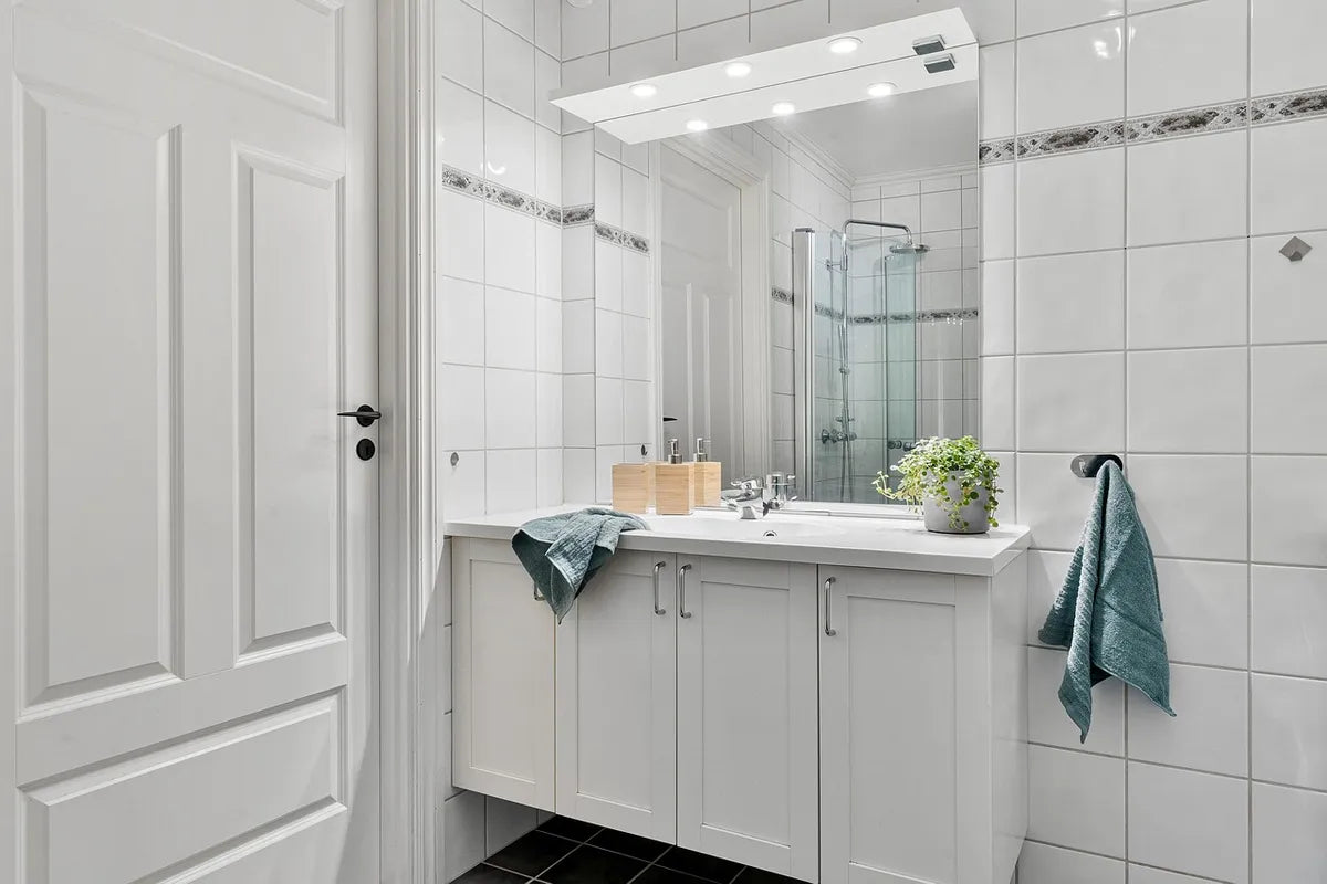 Salle de bain blanche avec douche et meuble vasque