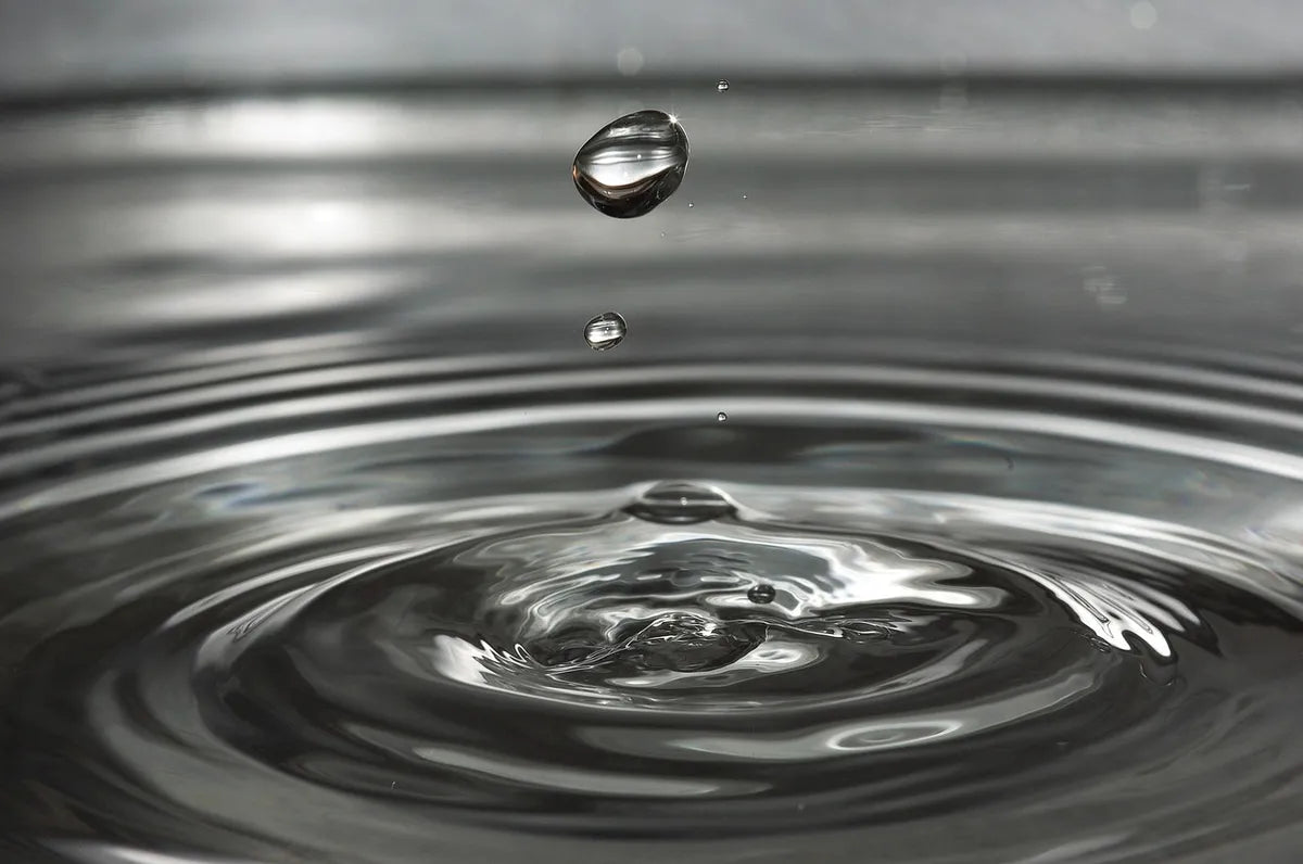 Gouttes d'eau formant des ondes à la surface