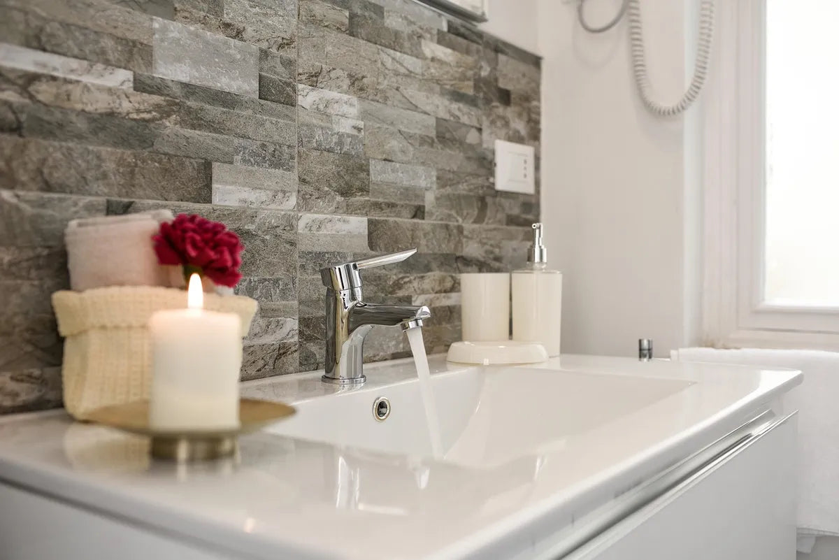 Salle de bain avec mur en pierre et bougie