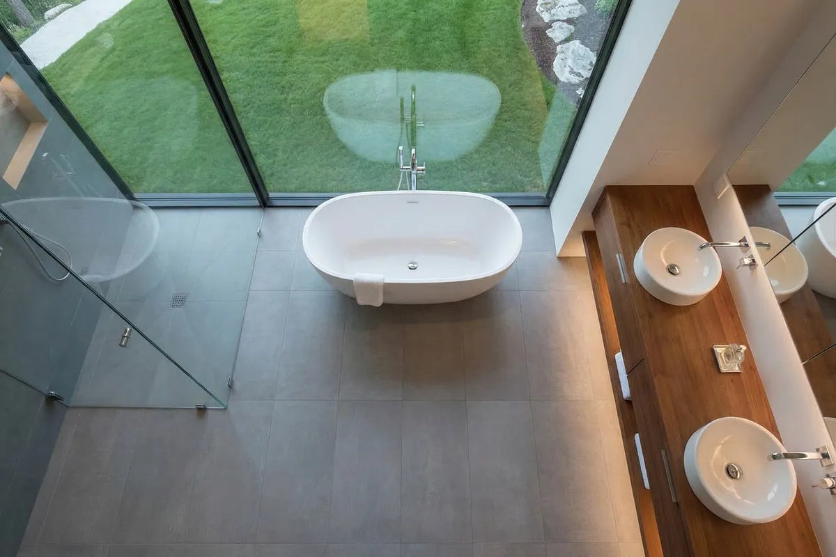 Salle de bain lumineuse avec baignoire et grande fenêtre