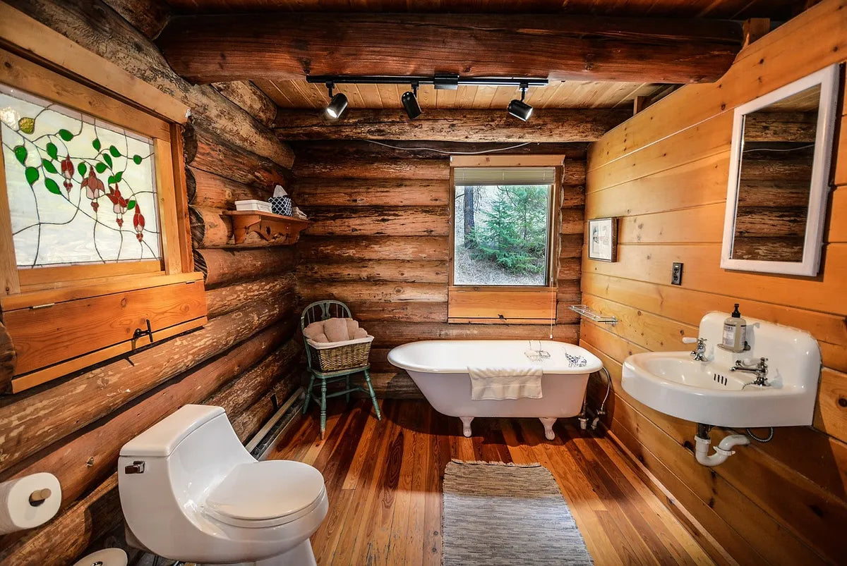 Salle de bain avec baignoire dans une maison en rondins