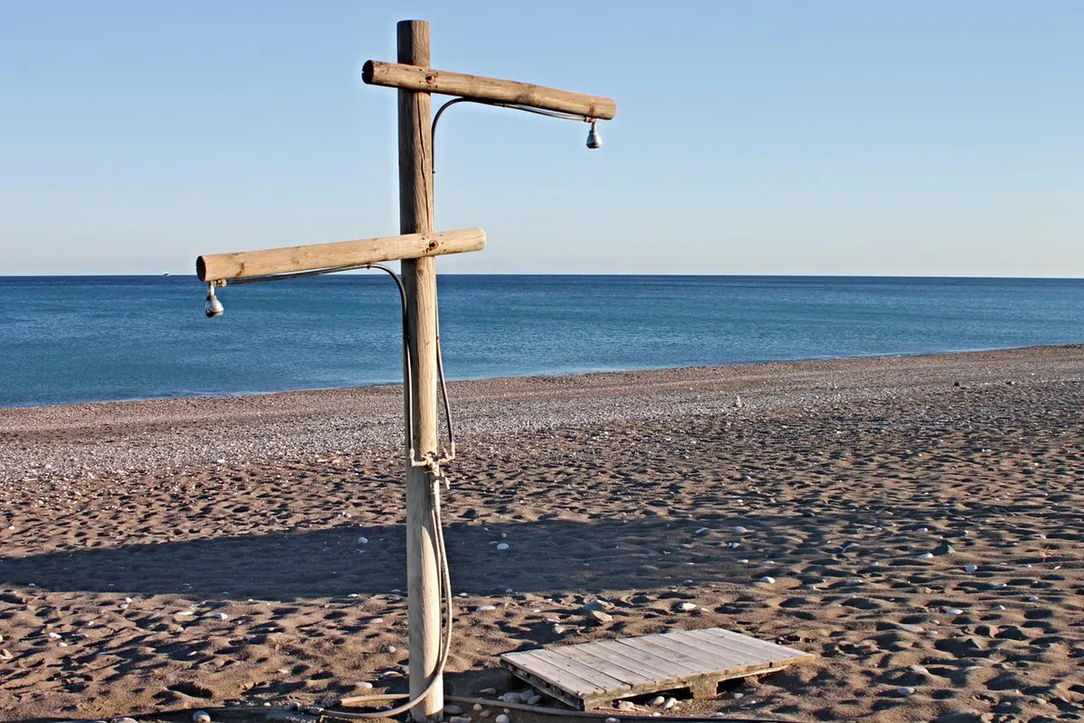 Douche extérieure sur une plage de galets