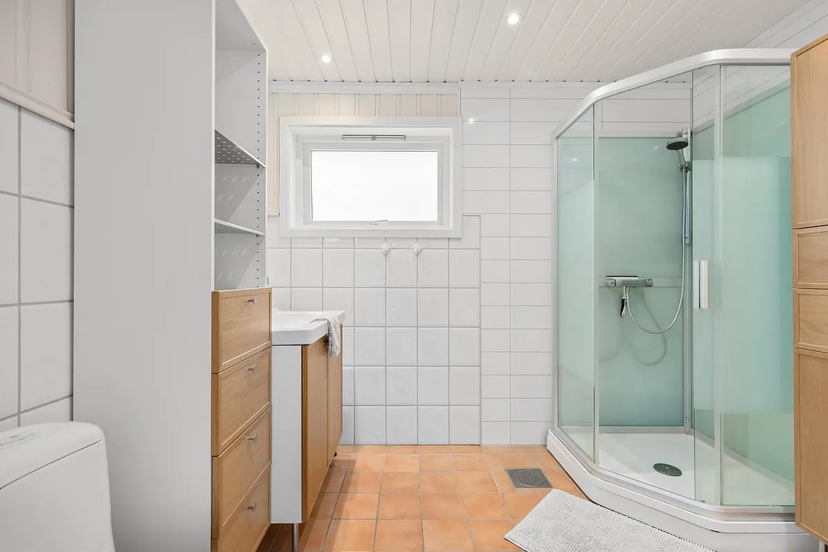 Salle de bain carrelée avec douche vitrée